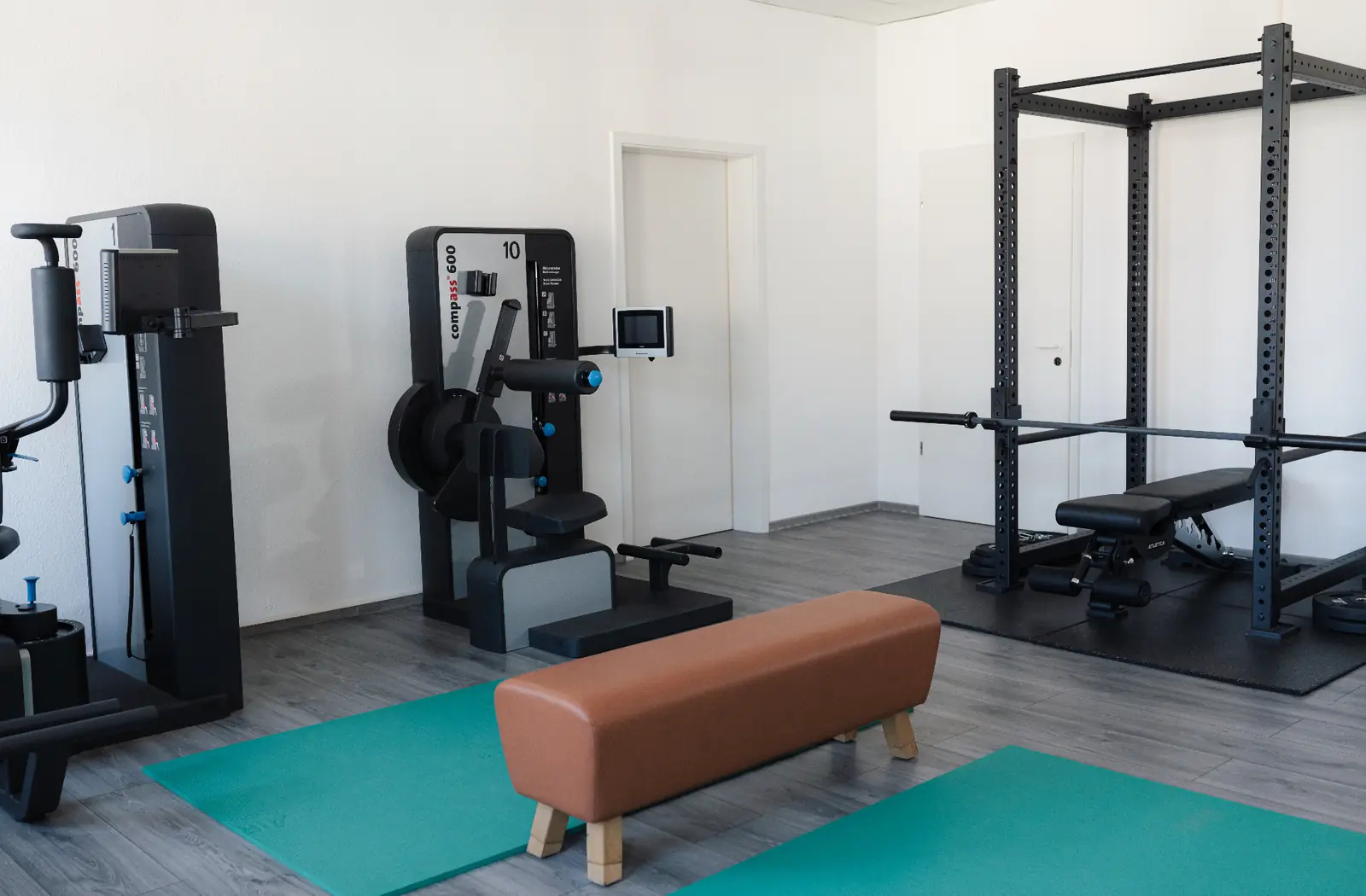 Trainingsbereich der Praxis Tenschert mit Compass-Trainingsgeräten, Rack und Sprungbank